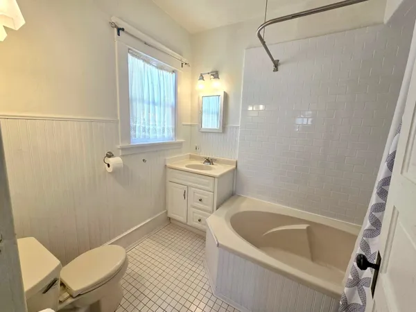 a bathroom with a sink a toilet a mirror and bathtub