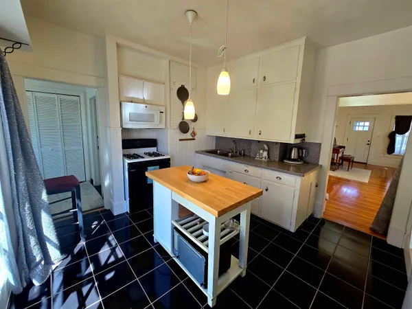 a kitchen with kitchen island granite countertop a stove a sink and a refrigerator