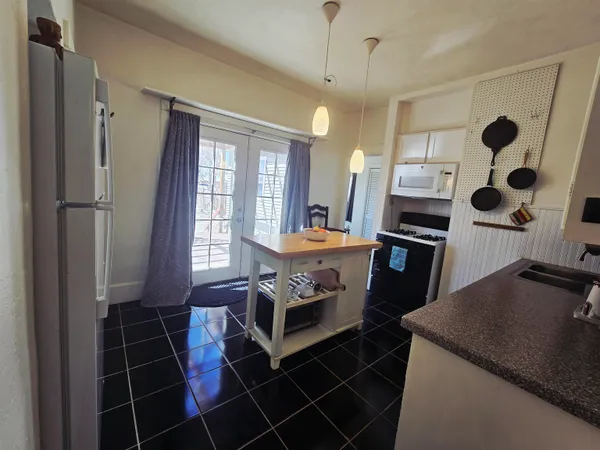 a kitchen with kitchen island a counter space a sink and appliances