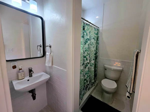 a bathroom with a toilet sink and mirror