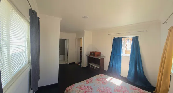 a bedroom with a bed and a large window