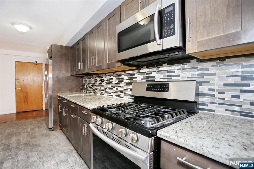 208 Anderson Street, Unit S4F Hackensack, NJ 07601 - Photo 4 of 20 a kitchen with a stove and a microwave