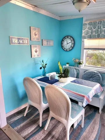 a bedroom with a bed a clock on wall and a large window