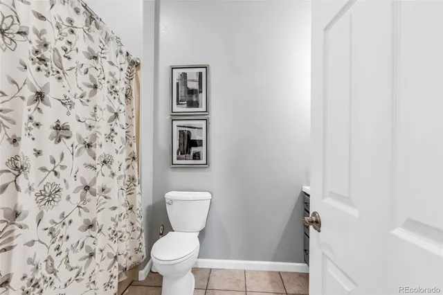 a a bathroom with a toilet and a shower curtain
