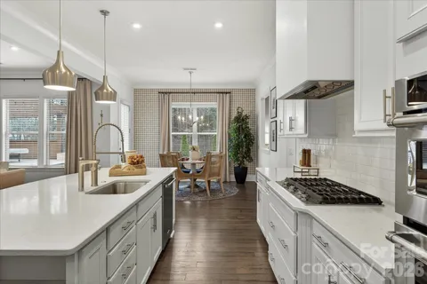 a kitchen with sink stove and cabinets