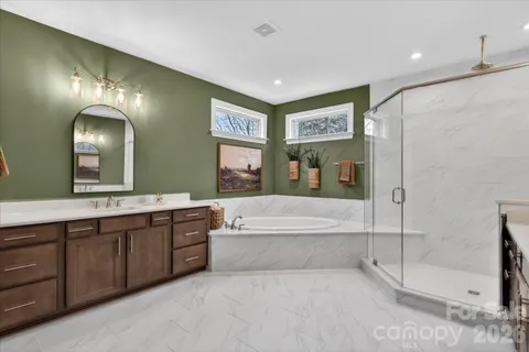 a spacious bathroom with a bathtub and a double vanity sink