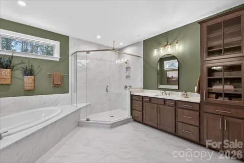 a spacious bathroom with a tub sink shower and mirror