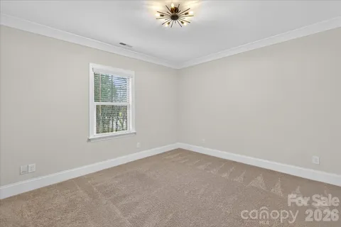 an empty room with a window and a ceiling fan