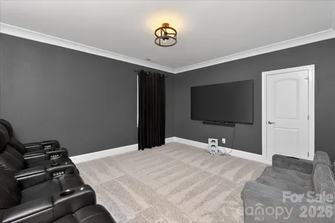 a bedroom with a bed and a flat tv screen on the dresser