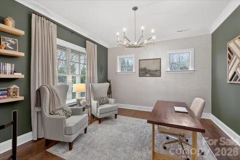 a living room with furniture a chandelier and a window
