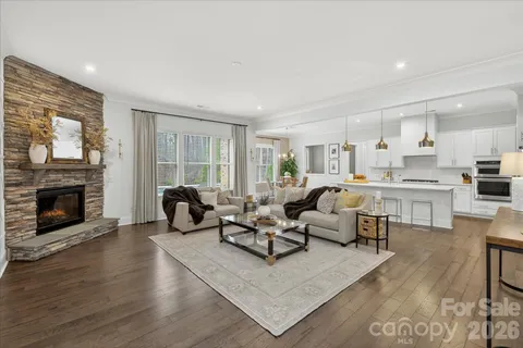 a living room with furniture kitchen view and a fireplace