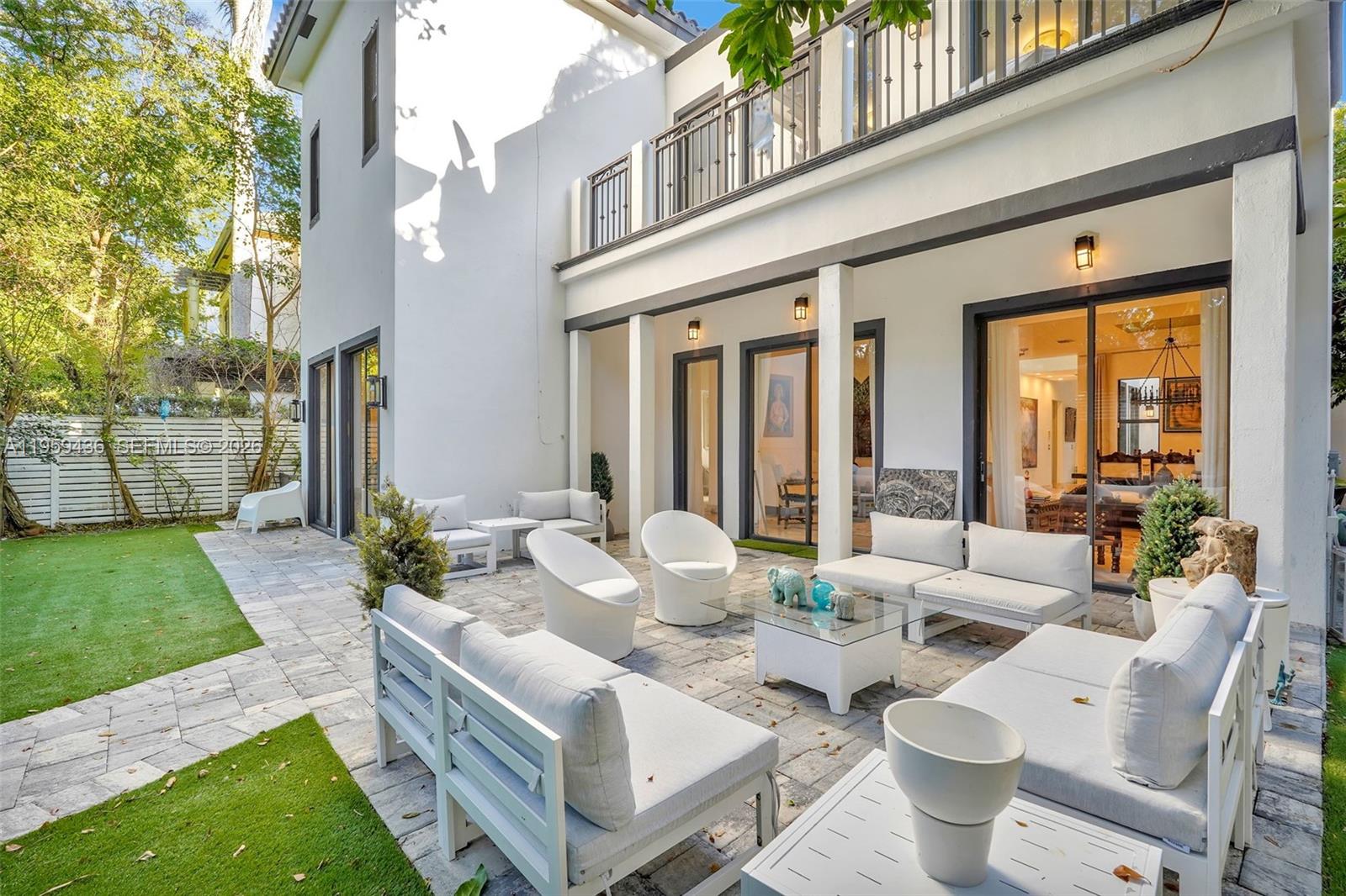 3675 Loquat Avenue Miami, FL 33133 - Photo 12 of 65 a view of a patio with couches table and chairs and potted plants