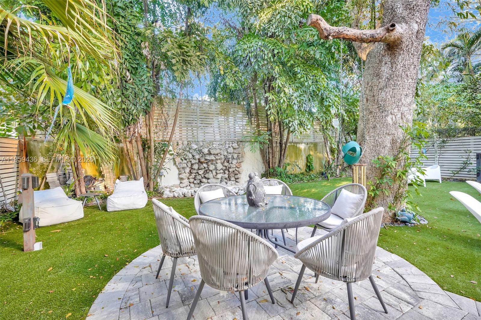 3675 Loquat Avenue Miami, FL 33133 - Photo 19 of 65 a view of a chairs and table in backyard of the house