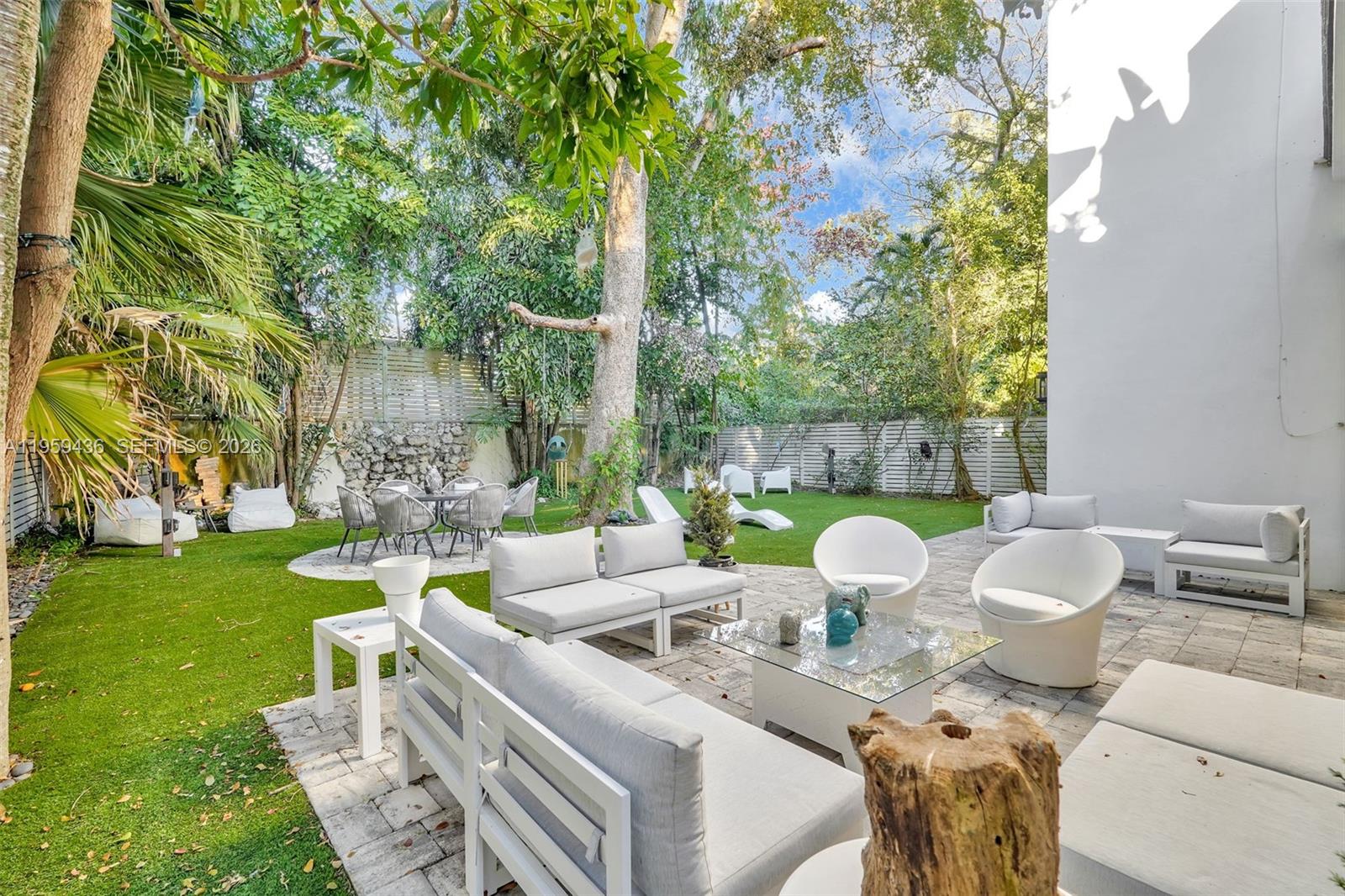 3675 Loquat Avenue Miami, FL 33133 - Photo 21 of 65 a view of a patio with couches table and chairs and garden