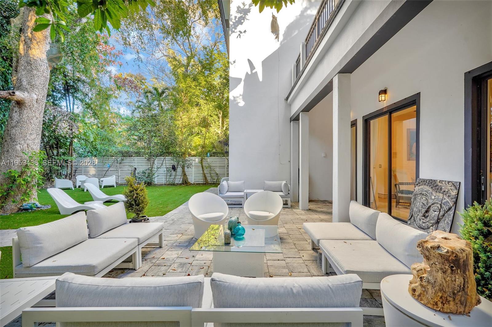 3675 Loquat Avenue Miami, FL 33133 - Photo 22 of 65 a view of a patio with couches table and chairs and potted plants