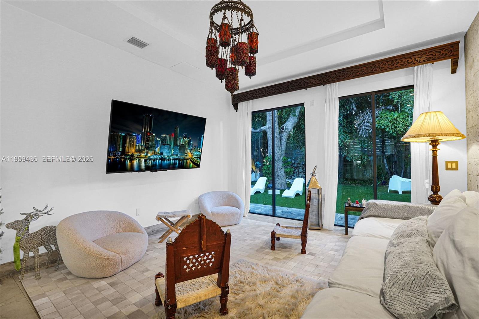 3675 Loquat Avenue Miami, FL 33133 - Photo 38 of 65 a living room with furniture a floor to ceiling window and a flat screen tv