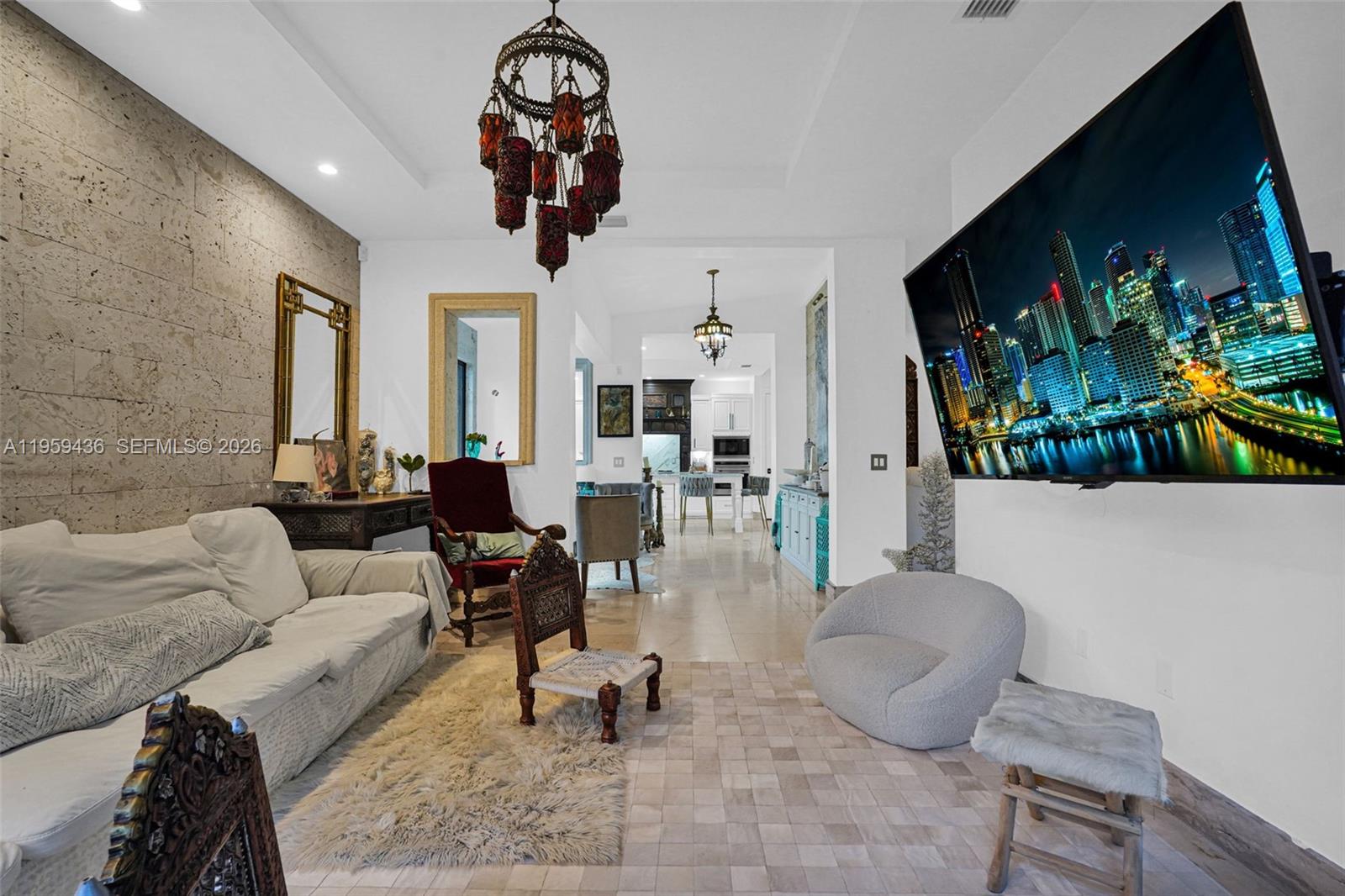 3675 Loquat Avenue Miami, FL 33133 - Photo 40 of 65 a living room with furniture a chandelier and a flat screen tv