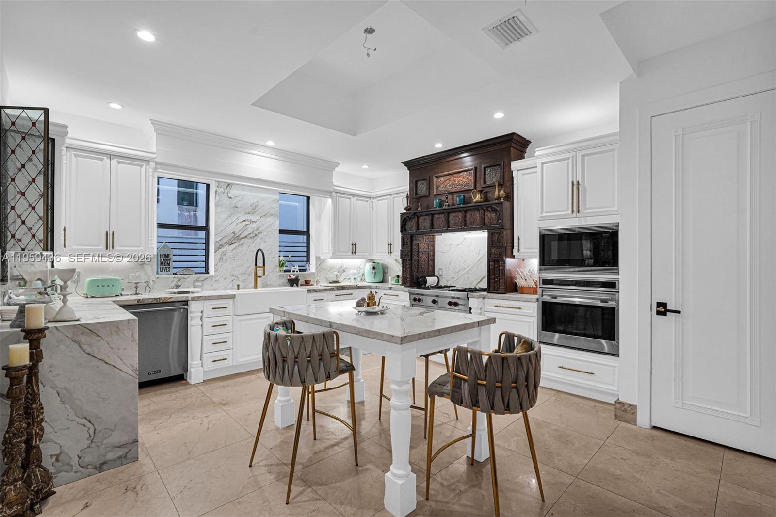 3675 Loquat Avenue Miami, FL 33133 - Photo 43 of 65 a kitchen with stainless steel appliances granite countertop a stove top oven a sink dishwasher a dining table and chairs with wooden floor