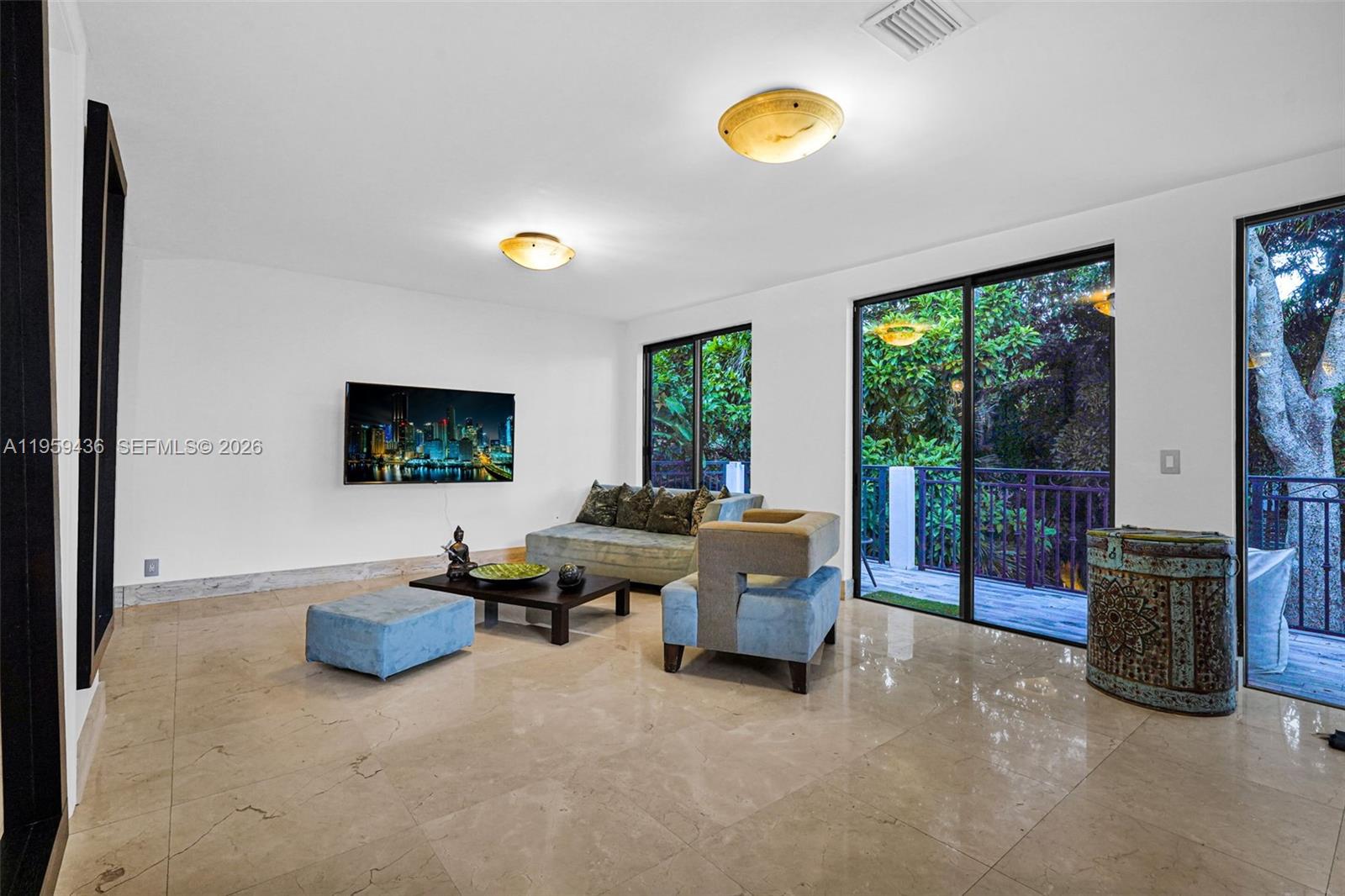 3675 Loquat Avenue Miami, FL 33133 - Photo 59 of 65 a living room with furniture and a flat screen tv