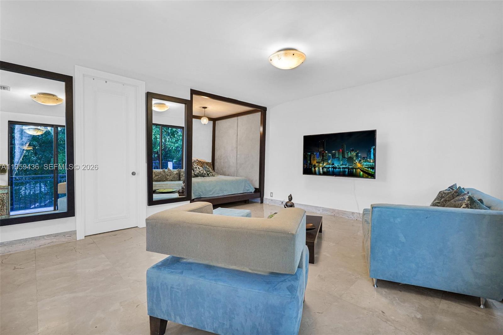3675 Loquat Avenue Miami, FL 33133 - Photo 61 of 65 a bedroom with furniture and a flat screen tv