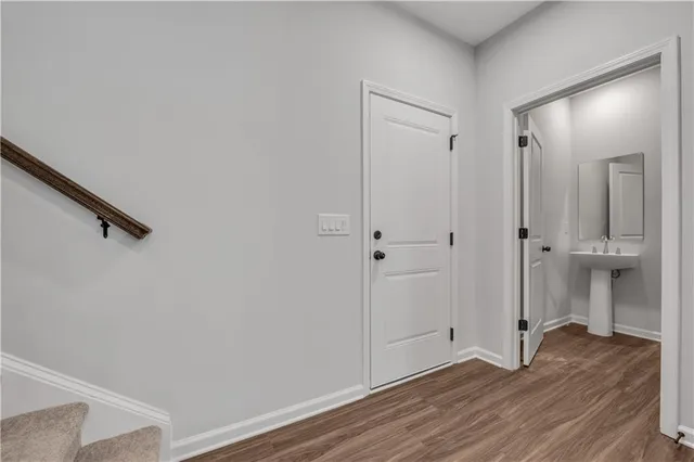a view of a livingroom with wooden floor and a bathroom