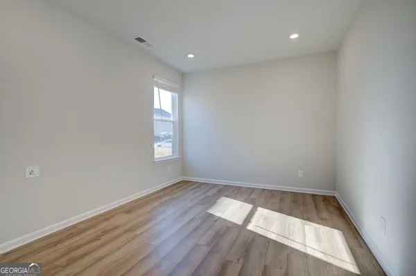 a view of a hallway with wooden floor and stairs
