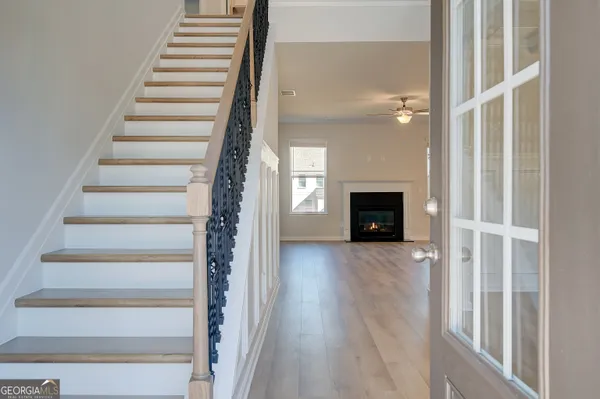 a view of a hallway with wooden floor and front door