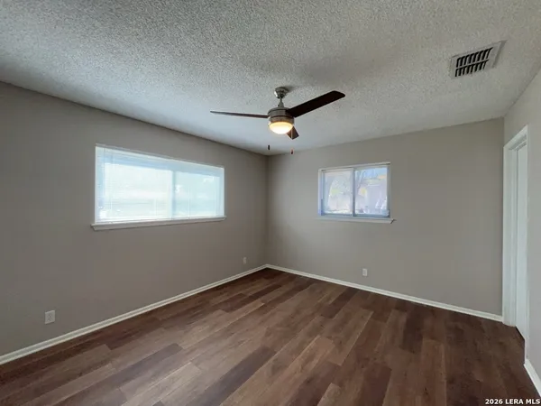 a view of an empty room with wooden floor