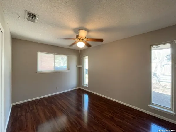an empty room with wooden floor and window