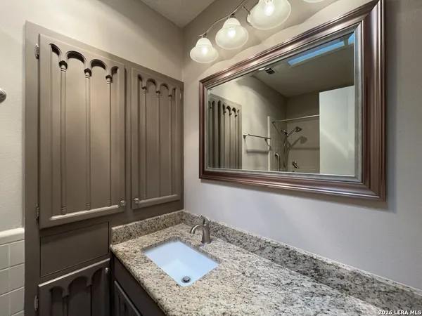 a bathroom with a sink a toilet and shower