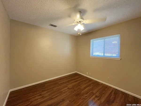 a view of an empty room with wooden floor