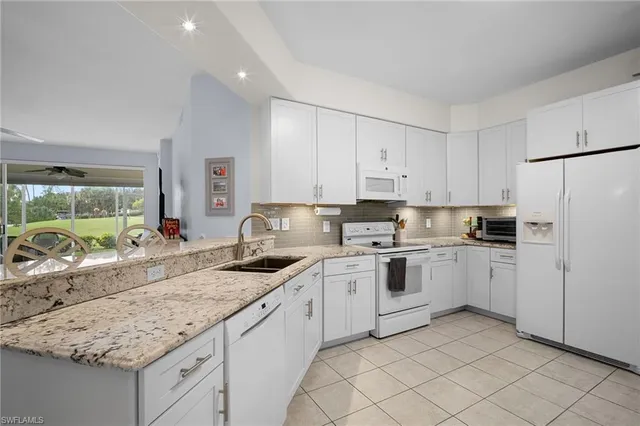 a kitchen with granite countertop cabinets stainless steel appliances a sink and a counter top space