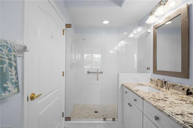 a bathroom with a granite countertop sink toilet and shower