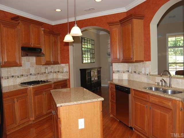6227 Oconner Street Raleigh, NC 27617 - Photo 4 of 11 Hardwood floor, 42" raised panel sherry cabinets, granite countertop, tile back splash, island, stainless steel appliances include: gas cook top, convection wall oven, built in microwave; pantry, 2 upgraded pendant lights, pass through to living room Kitchen
