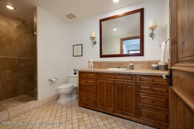 a bathroom with a sink a toilet and mirror