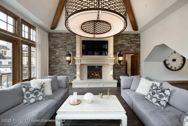 a living room with furniture a clock and a fireplace
