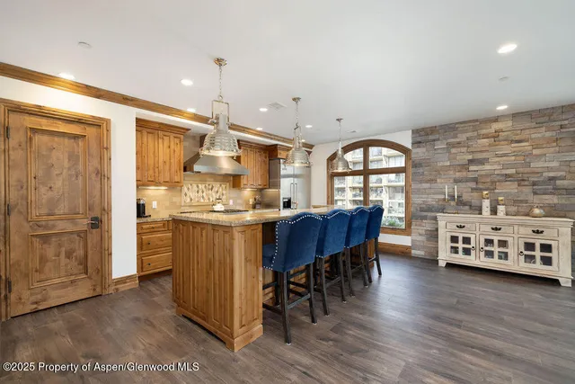 a kitchen with kitchen island wooden floors and wooden cabinets