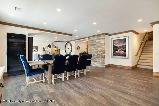 a living room with furniture a dining table wooden floor and a fireplace