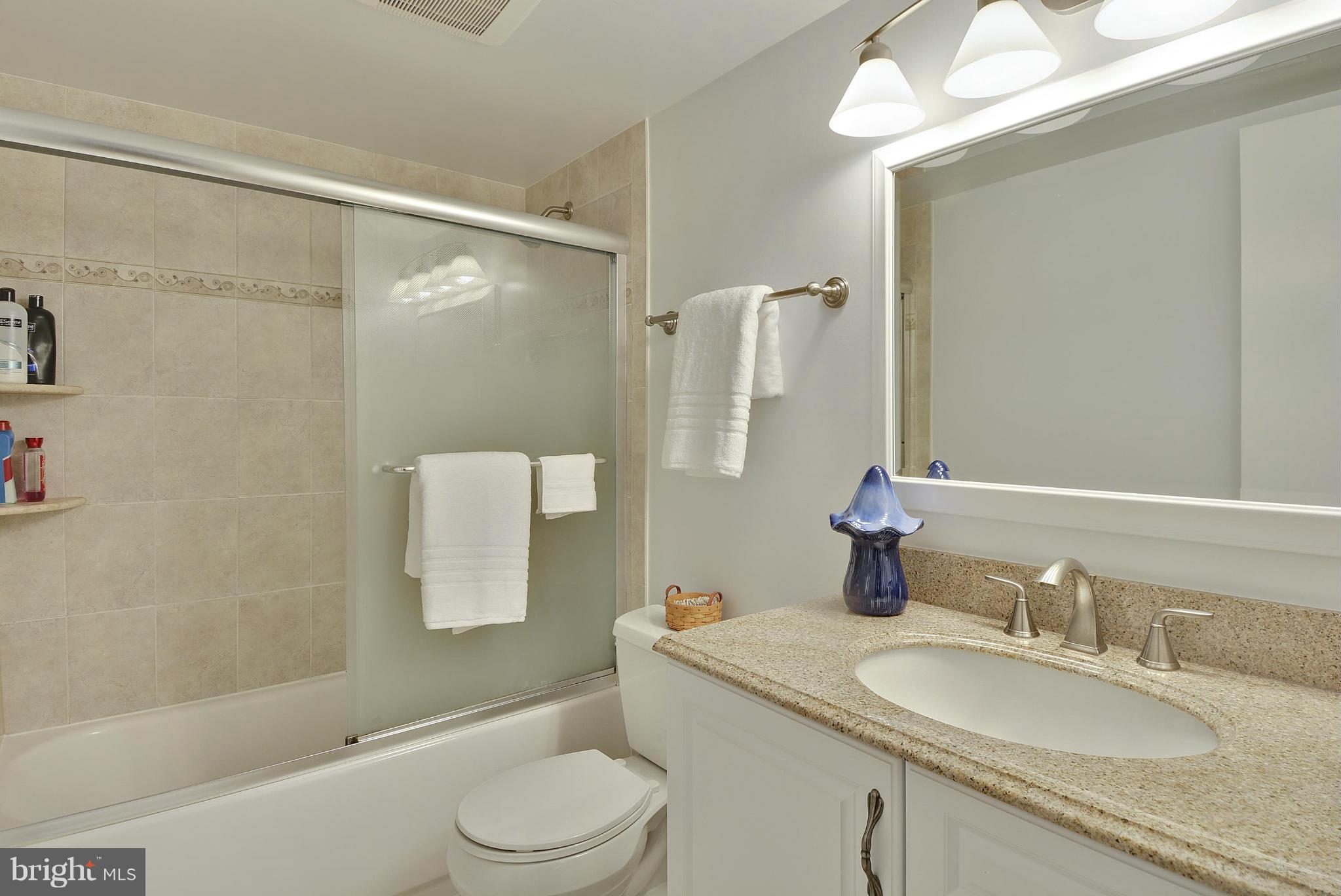 6731 Houndmaster Road Springfield, VA 22152 - Photo 18 of 30 a bathroom with a granite countertop sink toilet and shower