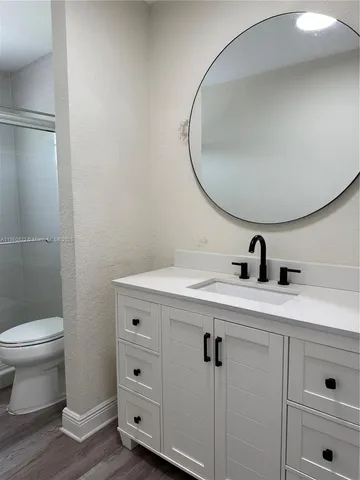 a bathroom with a toilet a sink and mirror