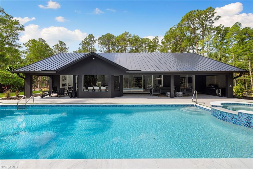 4521 3rd Avenue Northwest Naples, FL 34119 - Photo 24 of 46 a front view of a house with swimming pool having outdoor seating