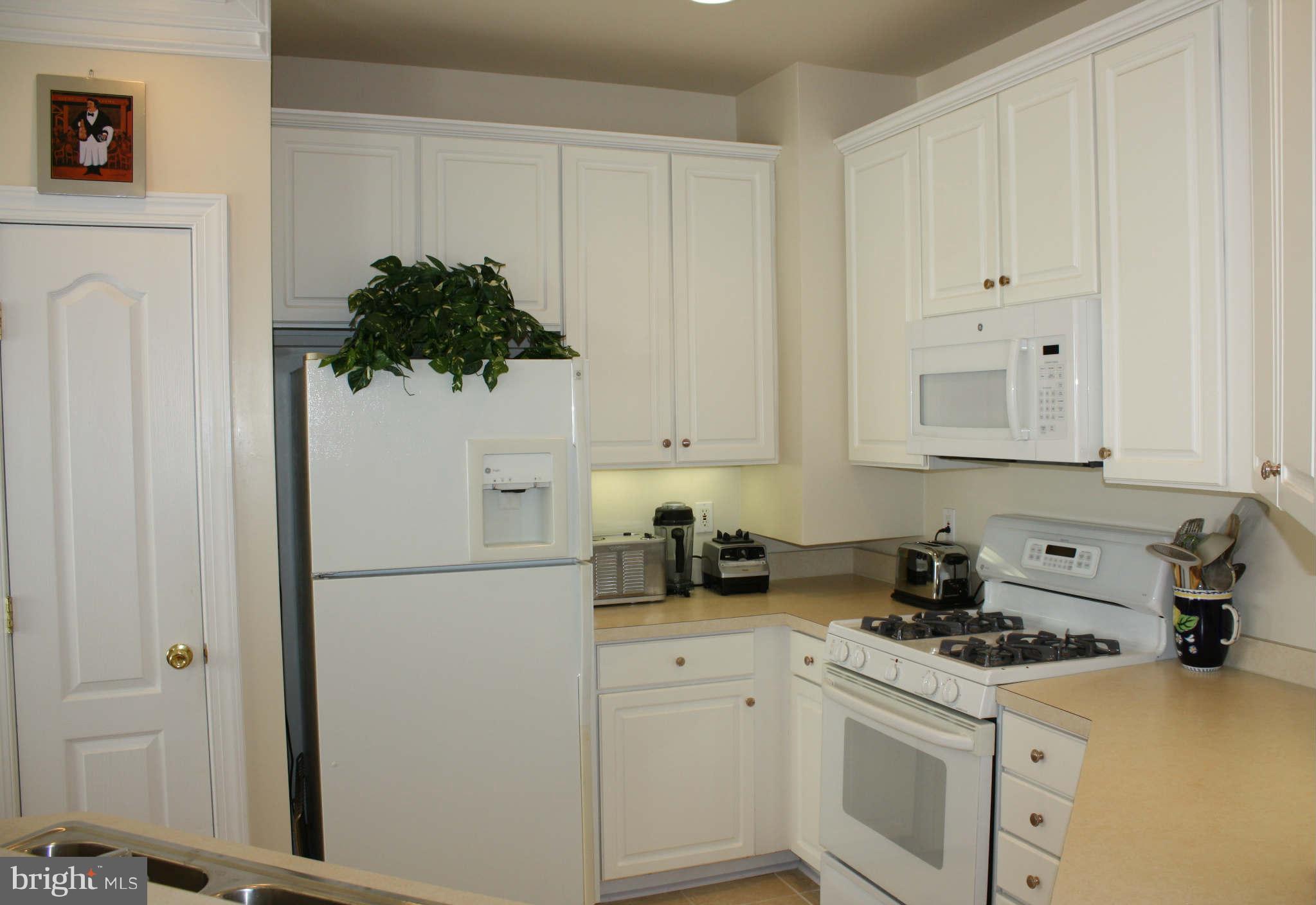 8075 Gatehouse Road, Unit 24 Falls Church, VA 22042 - Photo 11 of 24 a kitchen with stainless steel appliances white cabinets and a refrigerator