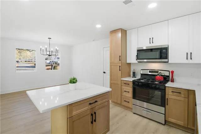 a kitchen with stainless steel appliances a stove microwave and refrigerator