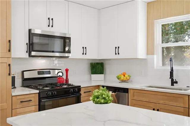 a kitchen with stainless steel appliances a stove a microwave and cabinets