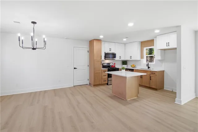 a kitchen with a sink cabinets and wooden floor