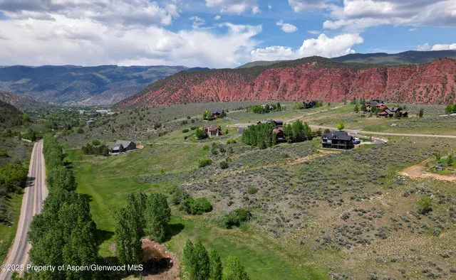 a view of a lush green field with mountains in the background