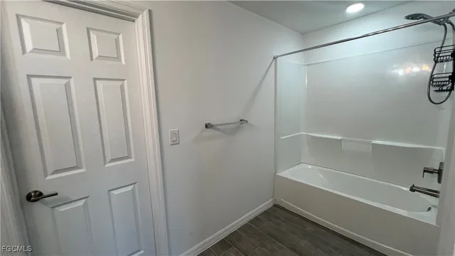 a bathroom with a granite countertop sink a mirror and a bathtub