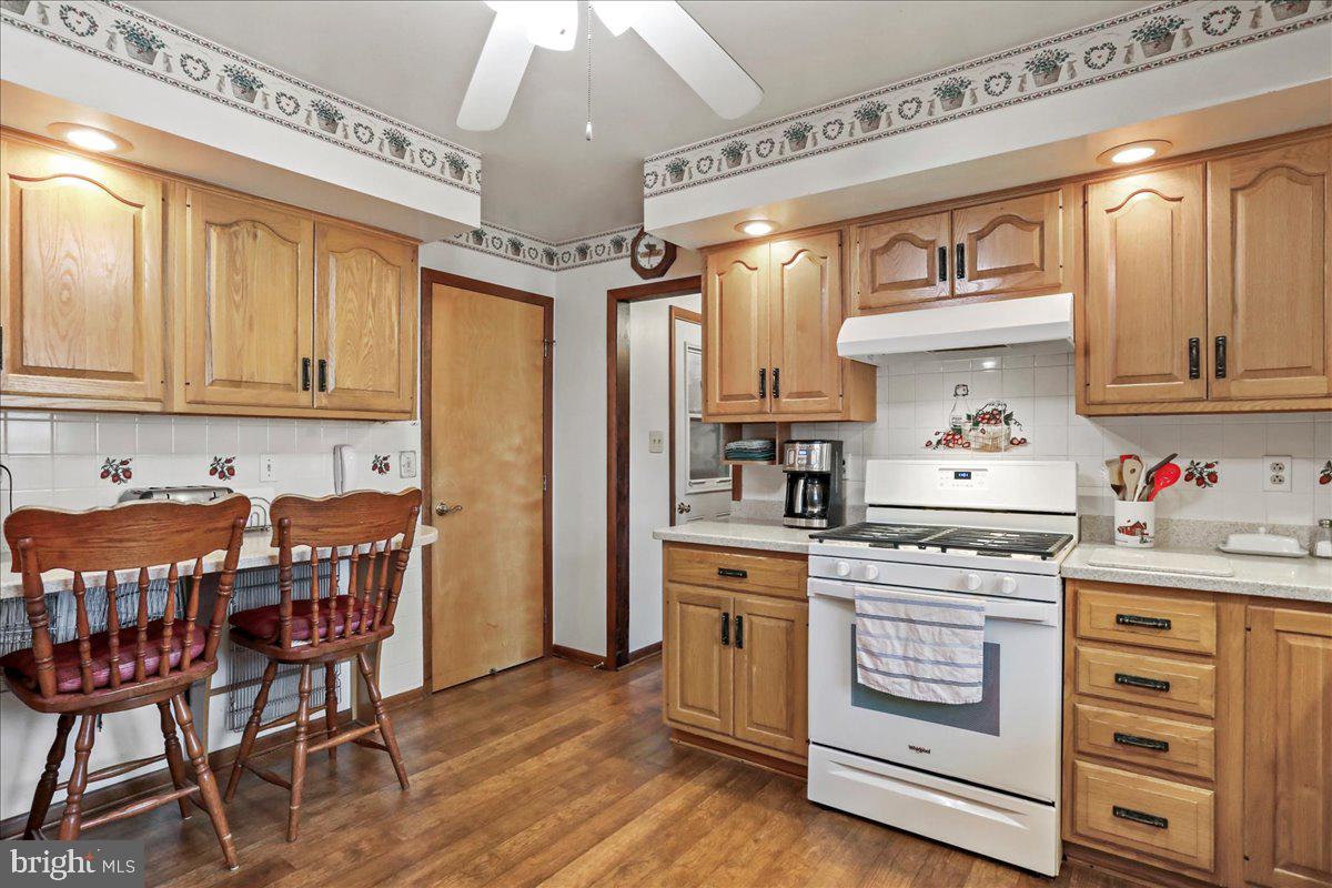 8920 Orndorff Road Emmitsburg, MD 21727 - Photo 59 of 91 a kitchen with stainless steel appliances granite countertop a stove top oven a dining table and chairs with wooden floor