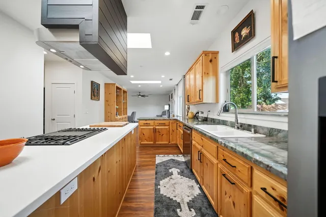 a kitchen with stainless steel appliances granite countertop a sink stove and cabinets