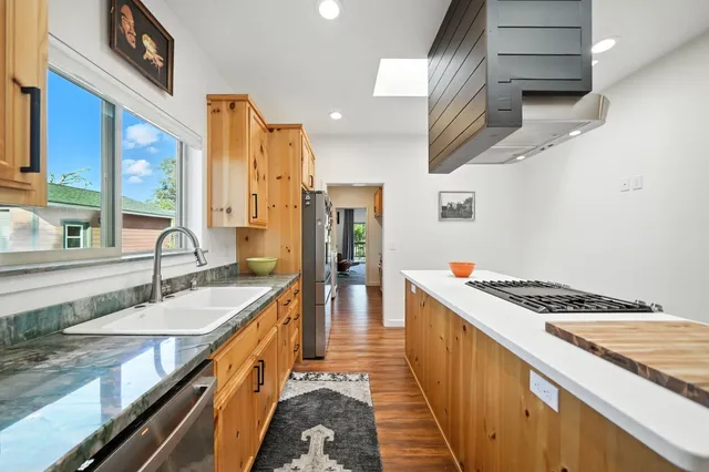 a kitchen with stainless steel appliances granite countertop a stove and a sink